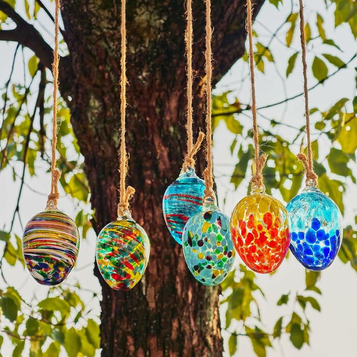 Colorful glass Easter eggs hanging on strings, perfect for filling your own Easter basket.