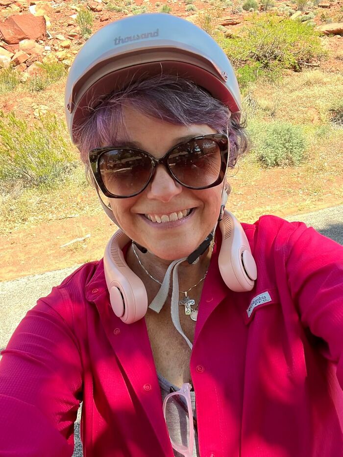 Woman in sunglasses and helmet with headphones, enjoying the outdoors. Festival survival kit must-have for 2023.