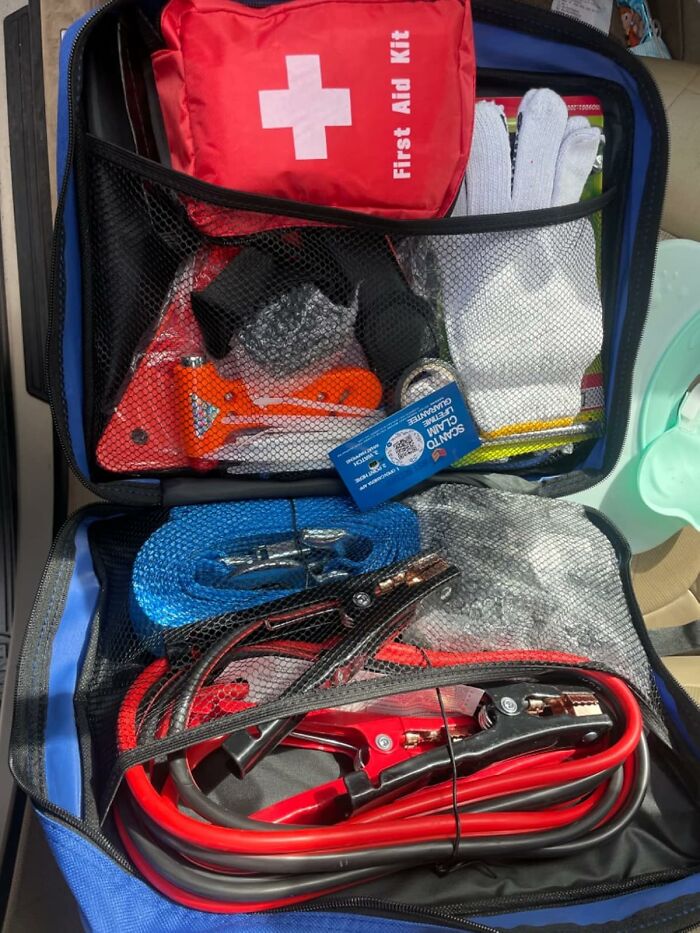 Car emergency kit with jumper cables, first aid supplies, gloves, and safety tools for practical car advice from Reddit.