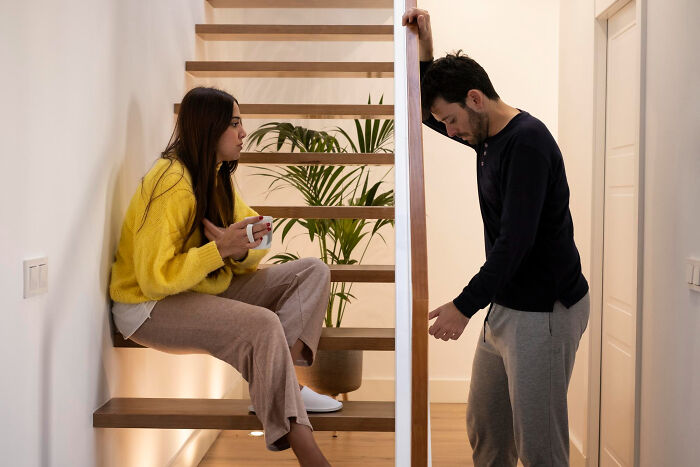 A man and woman in a tense conversation on stairs, illustrating why guys slept with a married woman situation.