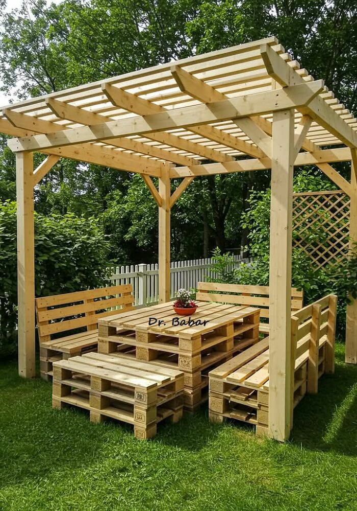 Outdoor wooden pergola and pallet furniture set in a garden showcasing creative woodworking ideas and wood works.