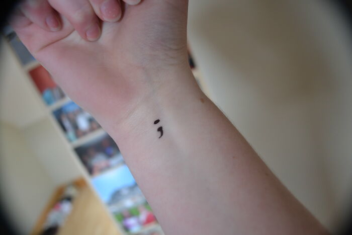 Semicolon tattoo on wrist symbolizing awareness and obvious things newly realized by the person.