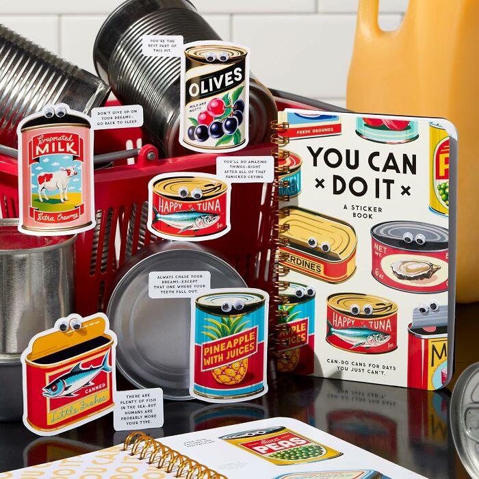 Colorful cans with googly eyes and motivational stickers arranged with a You Can Do It sticker book, playful nostalgia items.