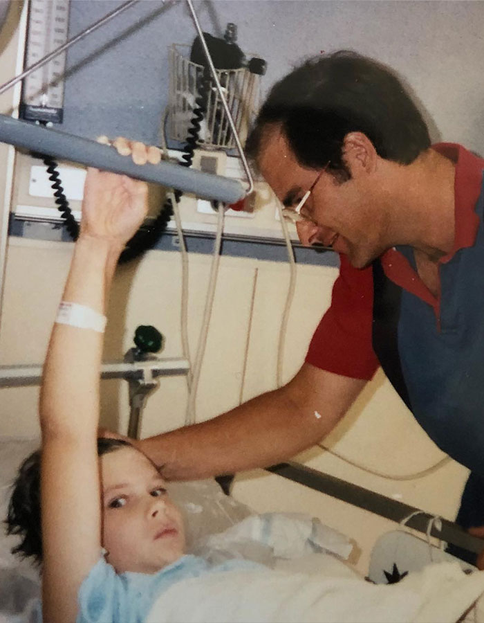 A person in a hospital bed with a man by their side after a cement truck crash.