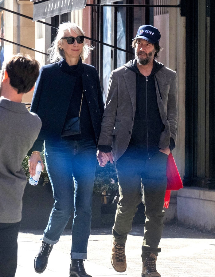 Couple walking outdoors; her youthful look compared to partner's sparks age confusion debate.