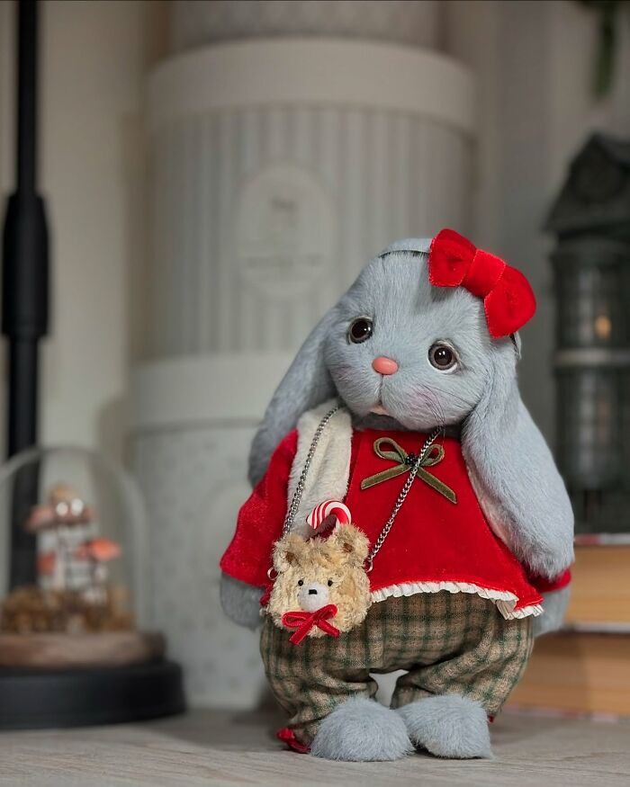 Handmade whimsical plush toy bunny in a red sweater and bow, featuring a small bear accessory.