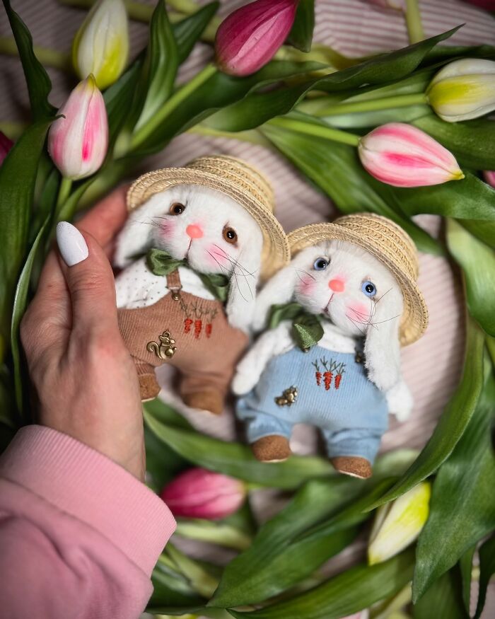 Whimsical plush toys, handmade rabbits in straw hats, surrounded by tulips.