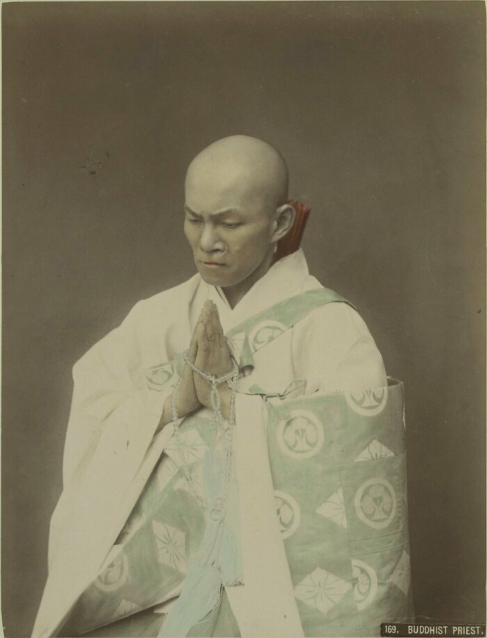 Buddhist priest in traditional robes praying, showing what Japan looked like in the 1800s with historical clothing and customs.