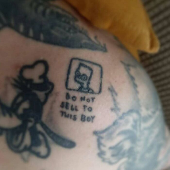 A blurry Simpsons tattoo with text "Do Not Sell To This Boy," depicting a humorous scene.