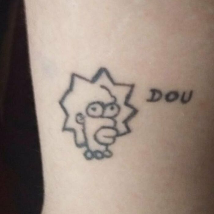 A poorly done Simpsons tattoo with a design featuring a character's head and the word "DOU" alongside.