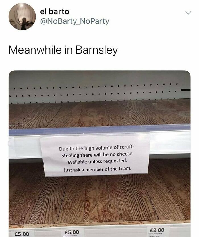 Empty British store shelf with a sign about cheese availability due to theft, humorously reflecting growing up British.