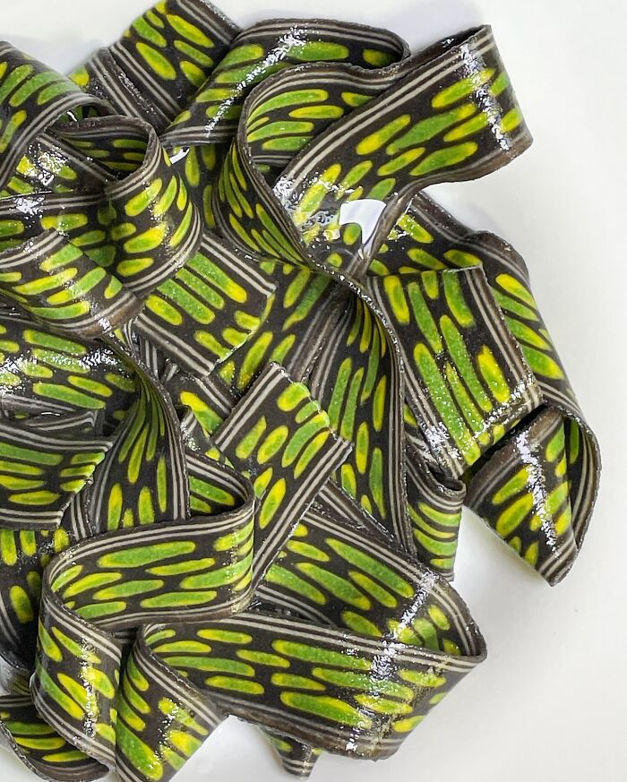 Handcrafted pasta with vibrant green and black patterns, showcasing a culinary artist's creative flair.