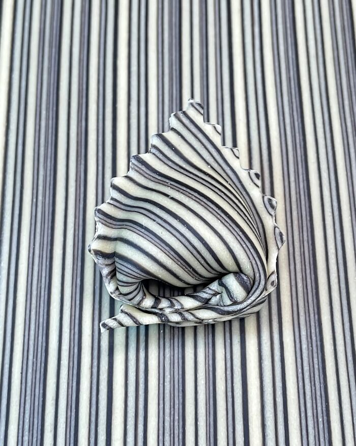 Handcrafted pasta with intricate black and white stripes, showcasing artistic culinary design.