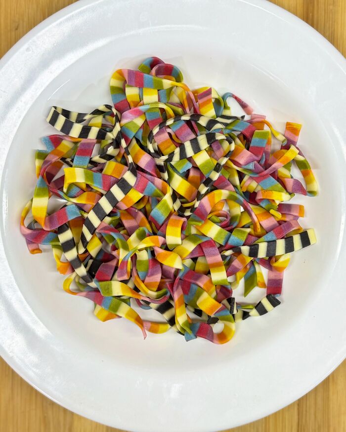 Colorful handcrafted pasta on a plate displaying intricate patterns by a culinary artist.