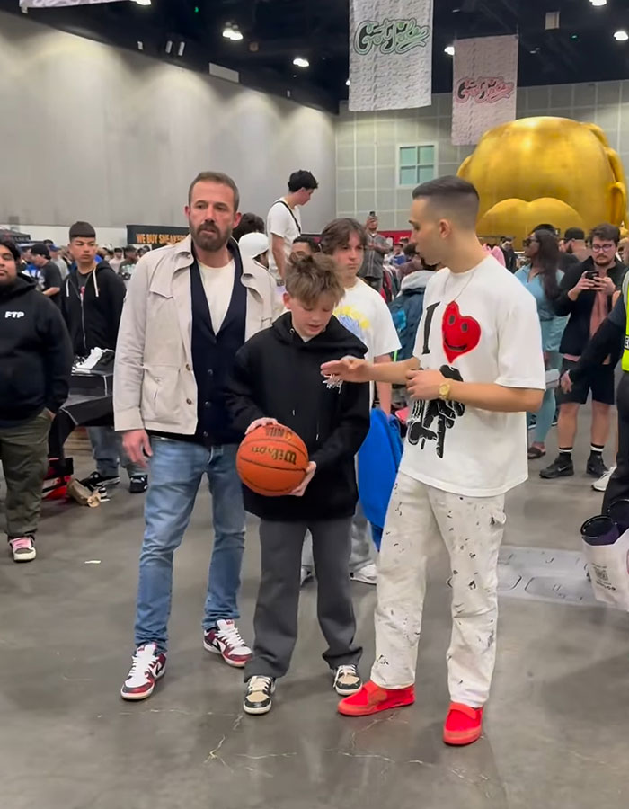 Ben Affleck with his children at a busy event, promoting hard work through regular jobs for rich kids.