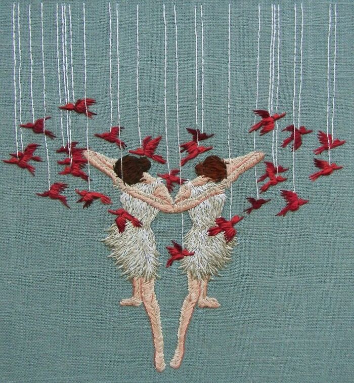 Two embroidered dancers with red birds, showcasing intricate embroidery work on a green background.