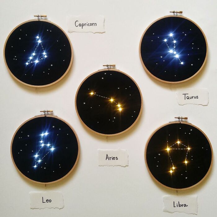 Five constellation embroidery works featuring Capricorn, Taurus, Leo, Aries, and Libra on dark fabric.