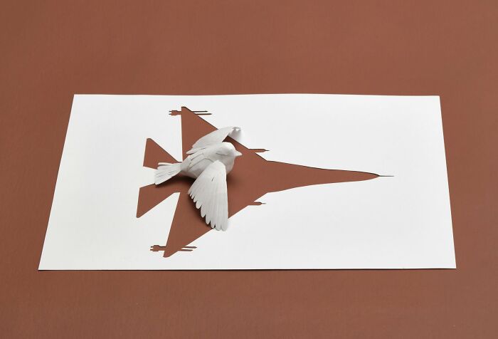 Paper art by Peter Callesen: a cutout of a plane transforms into a 3D bird on brown background.