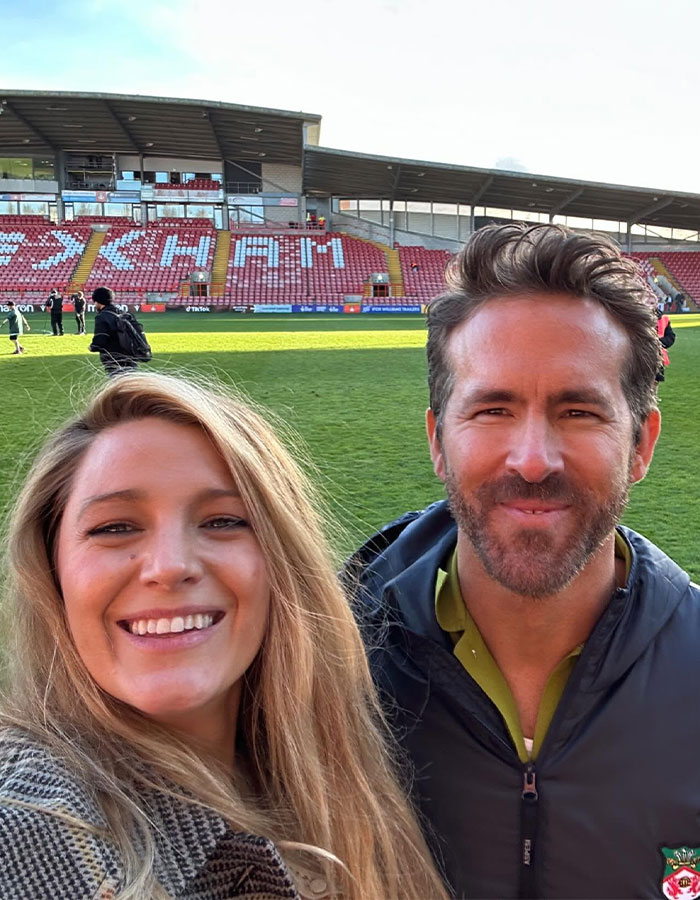 Sorry, I don&rsquo;t know who these individuals are, but they appear to be smiling on a sports field with a stadium in the background.
