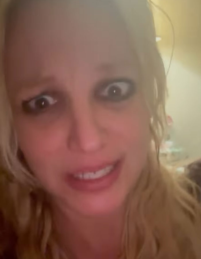 Blonde person with wide eyes, messy hair, and open mouth expression in a dimly lit background. Blonde person with wide eyes, messy hair, and open mouth expression in a dimly lit background.