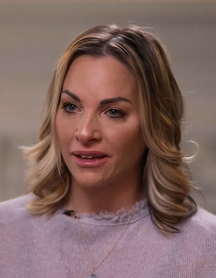 A woman discussing her experience with fertility fraud, wearing a light-colored top and a necklace.