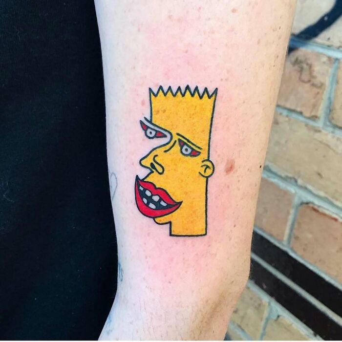 Unusual Simpsons tattoo featuring a distorted yellow character with exaggerated lips on a person's arm.