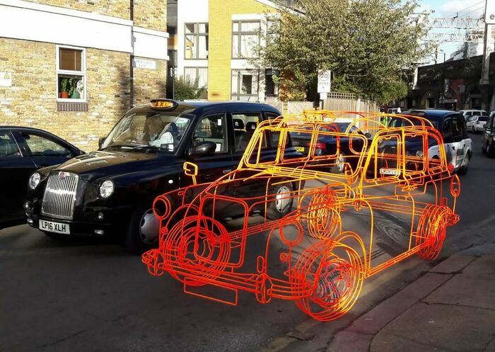 Unusual photo of an orange neon outline resembling a taxi on a street, creating a fake appearance at first glance.