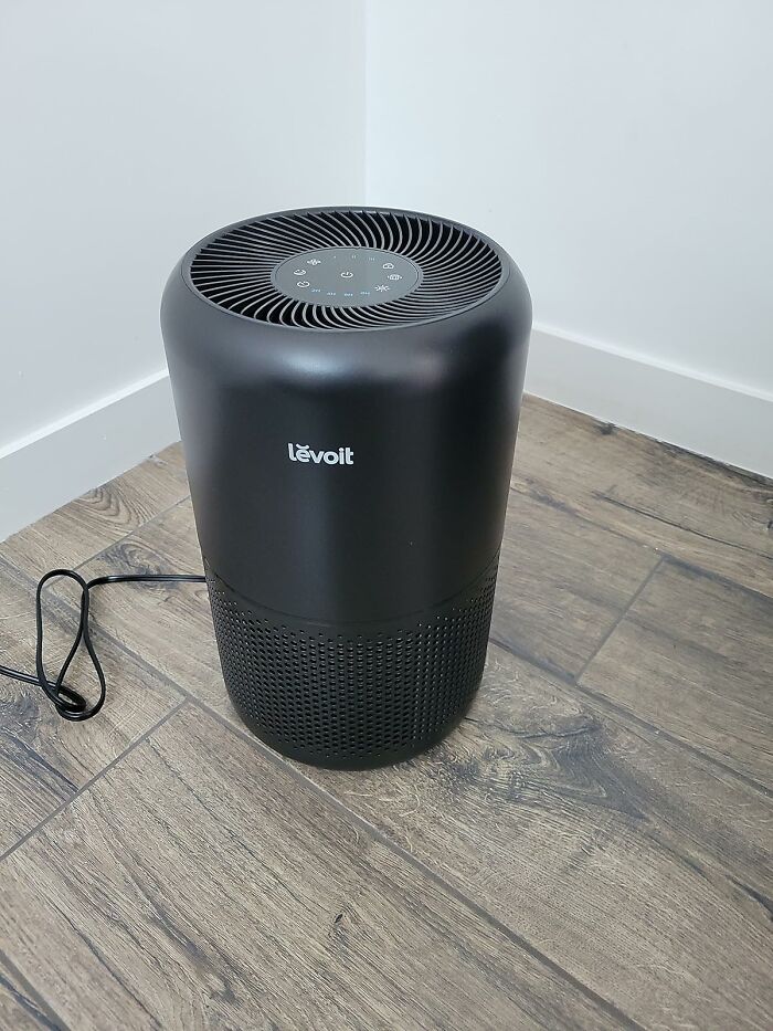 Stylish smart home air purifier on wooden floor, affordable and efficient.