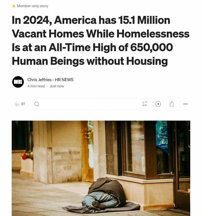 Homeless person sleeping in front of building highlights capitalism struggles with vacant homes and rising homelessness.