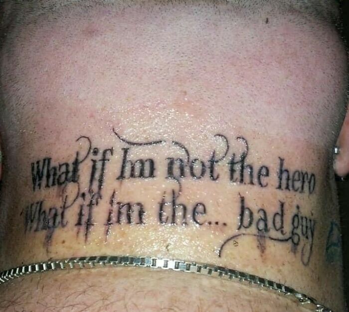 Tattoo on neck reading "What if I'm not the hero, What if I'm the... bad guy" in black script.