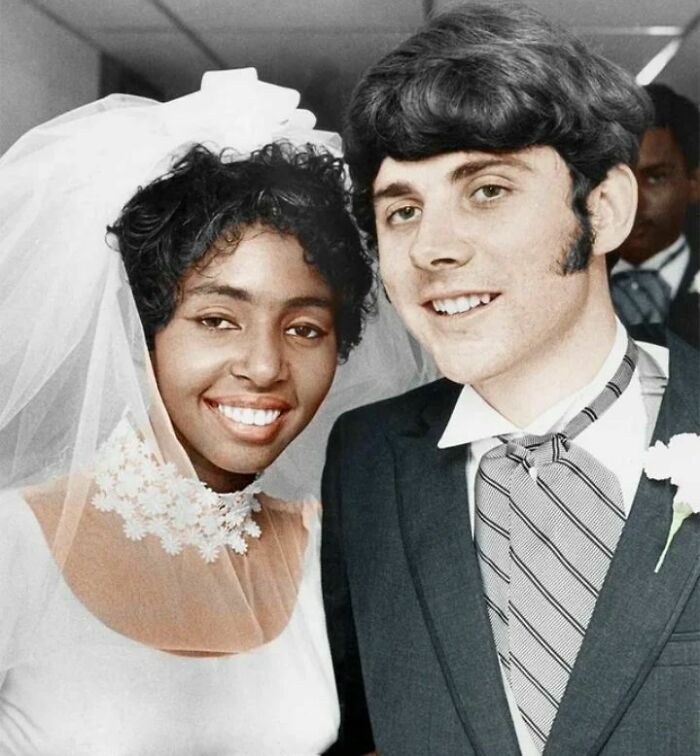 Vintage photo of a smiling interracial couple on their wedding day, capturing history up close and personal.