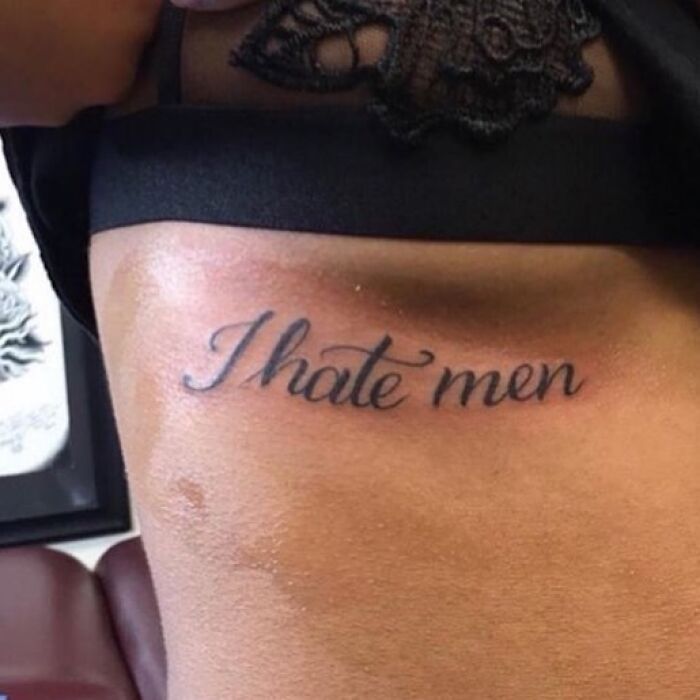 Tattoo mistake with text "I hate men" inked on skin.