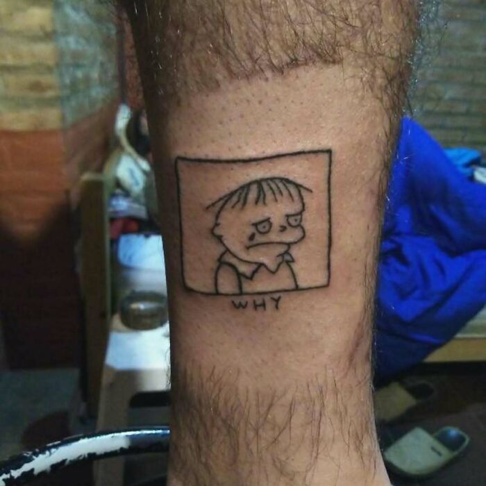 Simpsons tattoo featuring a sad character on a person's leg.