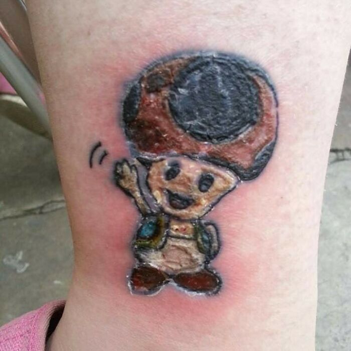Cartoon character tattoo inked on skin, showcasing one of many permanent mistakes.