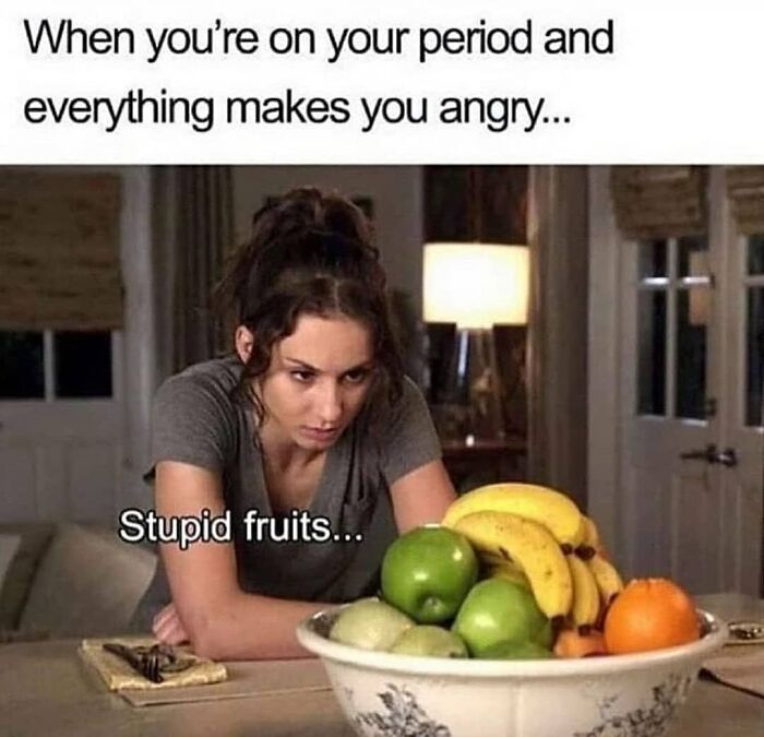 Woman looking frustrated at fruit bowl; humorous period meme highlighting mood swings.