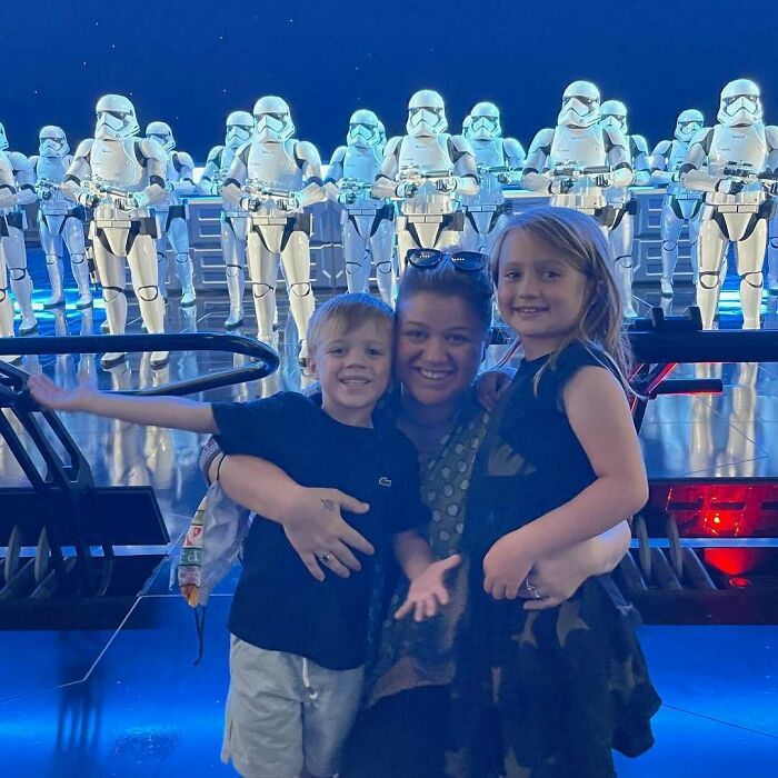 Family posing happily in front of a group of stormtroopers, capturing a memorable celebrity encounter moment.