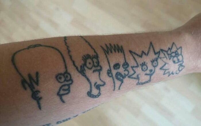 Simpsons tattoos featuring Homer, Marge, Bart, Lisa, and Maggie in black ink on an arm.