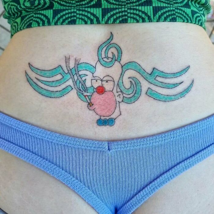 Tattoo of a cartoon character with wavy blue lines on a person's lower back, inspired by The Simpsons.
