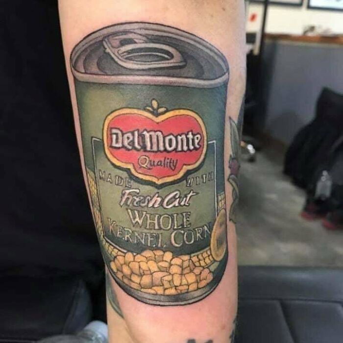 Tattoo of a Del Monte canned corn label on an arm, showcasing a permanent ink mistake.