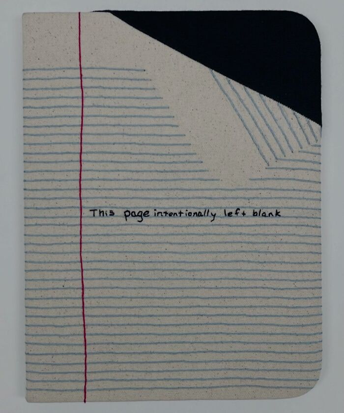 Embroidered fabric resembling a notebook page with text "This page intentionally left blank."