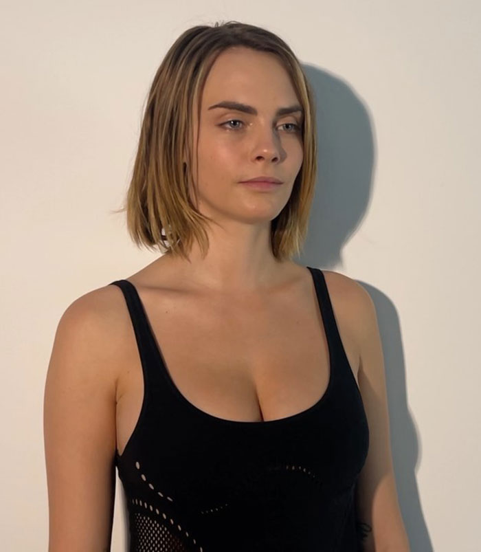 Woman with short hair in a black top, symbolizing dramatic transformation and sobriety.
