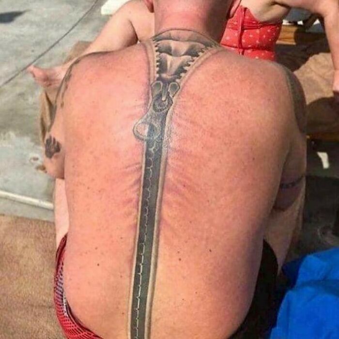 Man with a zipper tattoo on his back, showcasing a unique permanent mistake inked on his body.