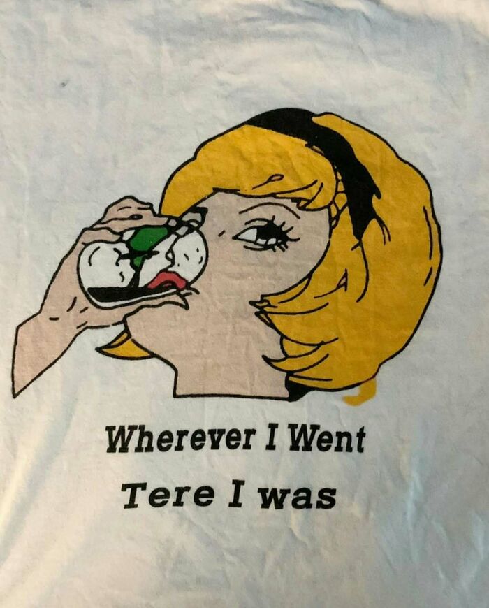 Cartoon woman drinking beverage; text reads "Wherever I Went Tere I was," illustrating a translation mishap on a T-shirt.