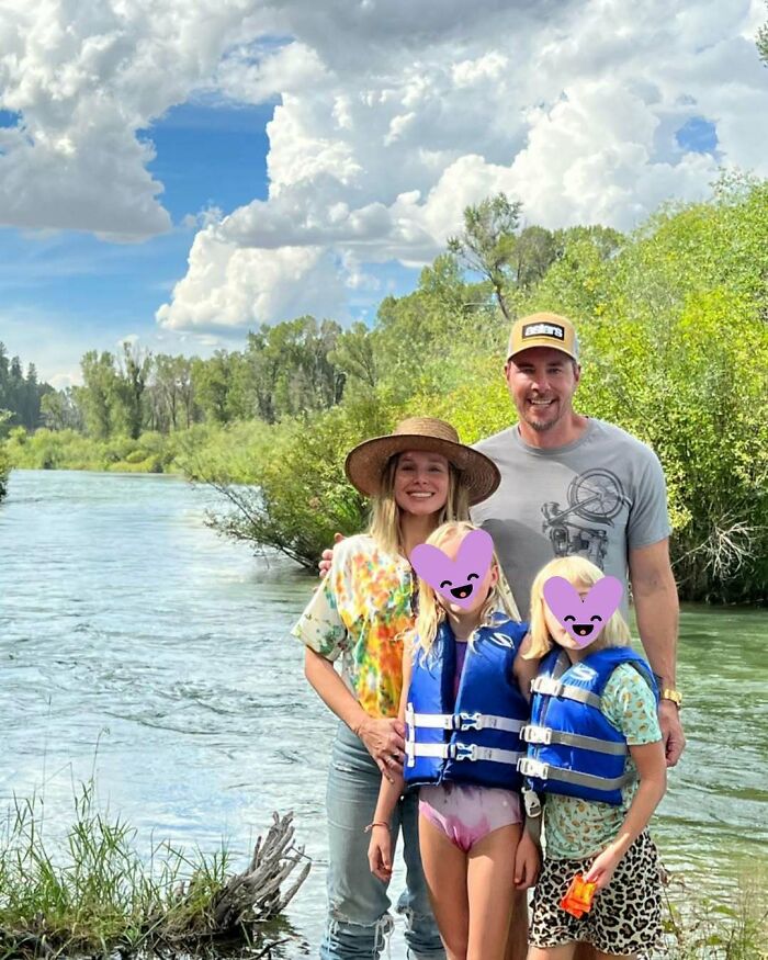Family enjoying a riverside outing with kids wearing life jackets in a memorable celebrity encounters moment outdoors.