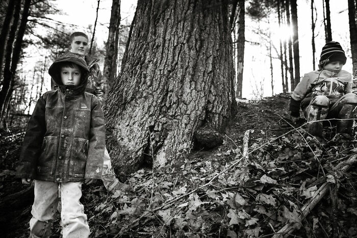Children exploring a wooded area, highlighting rural life in Maine.