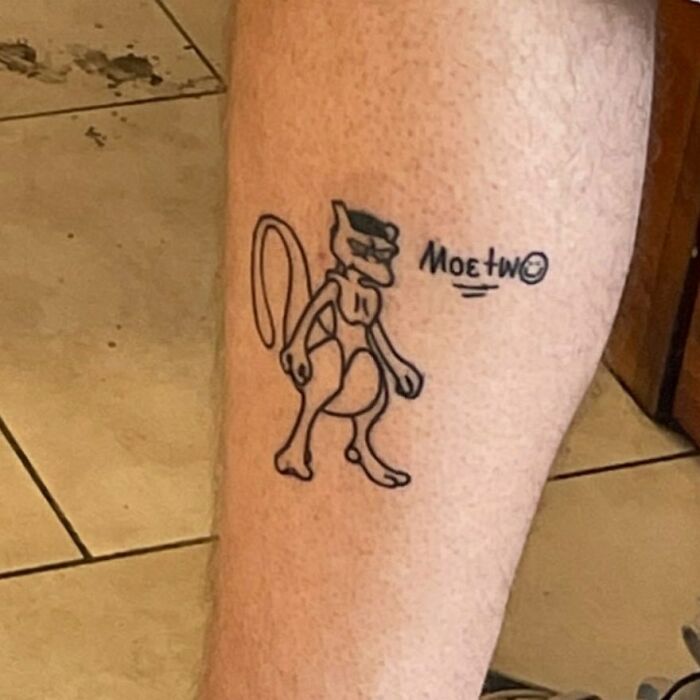 Tattoo of a character resembling Mewtwo with "Moe" theme on a leg, referencing Simpsons tattoos.