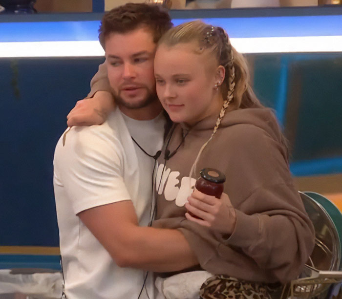 JoJo Siwa embracing a man on Big Brother set, both appearing cozy and relaxed.