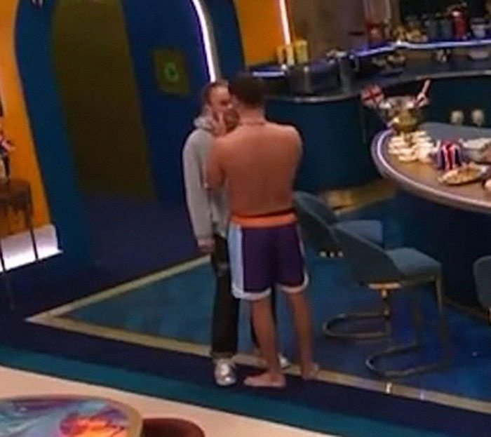 Two people in an intimate moment on Big Brother set.