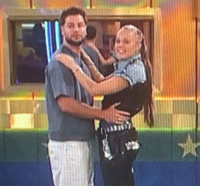 Two people sharing an intimate moment on Big Brother, embracing each other warmly.