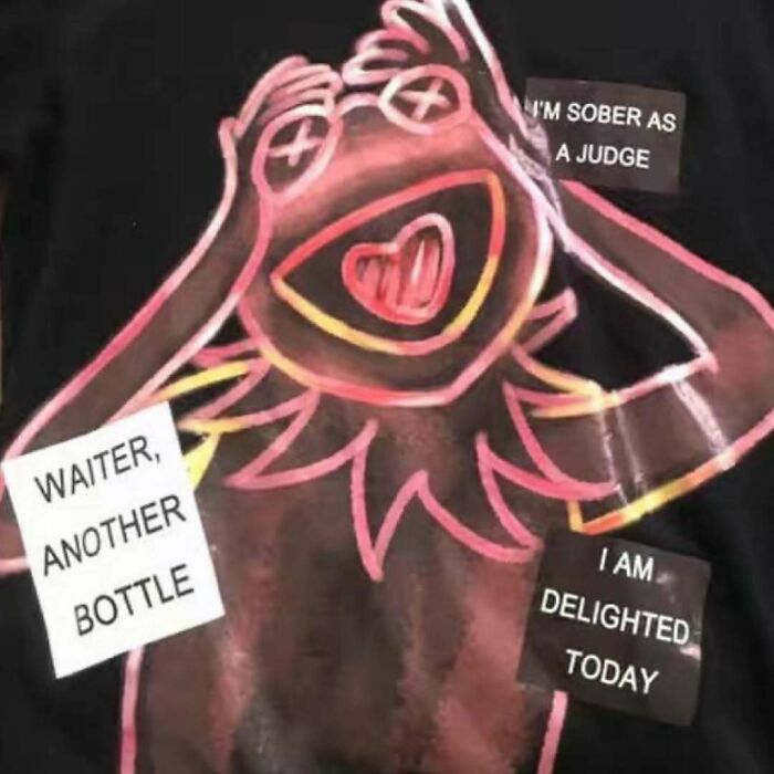 Cartoon character on shirt with funny translation mishaps: "Waiter, another bottle" and "I'm sober as a judge."